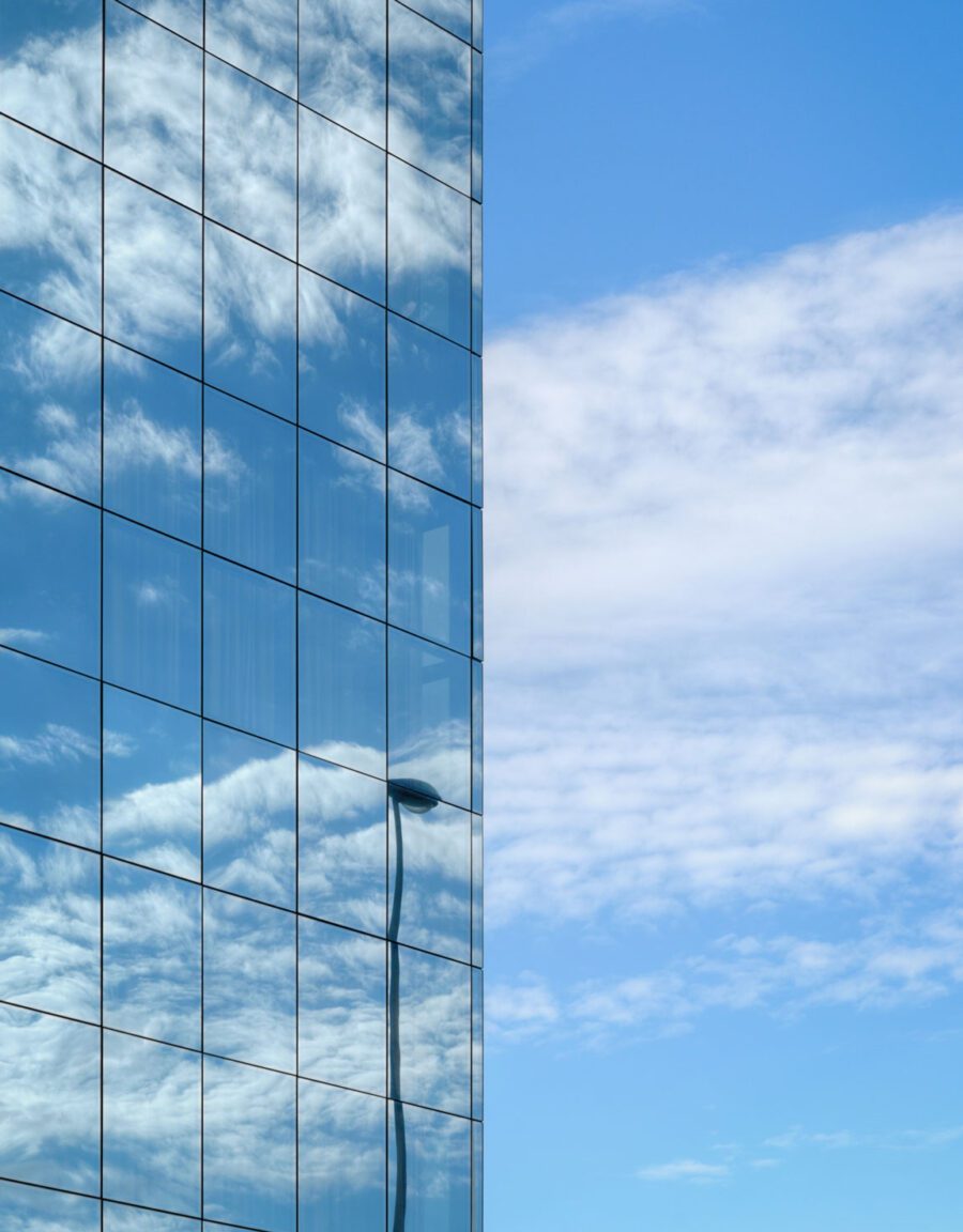 glass building reflecting clouds